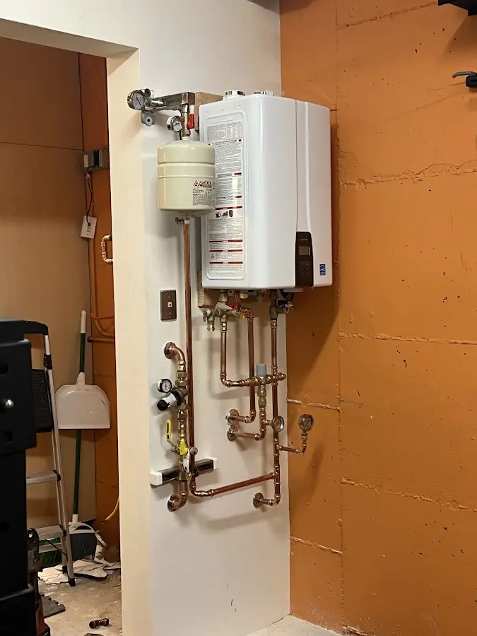 Plumbing technician inspecting water heater connections in Roosevelt